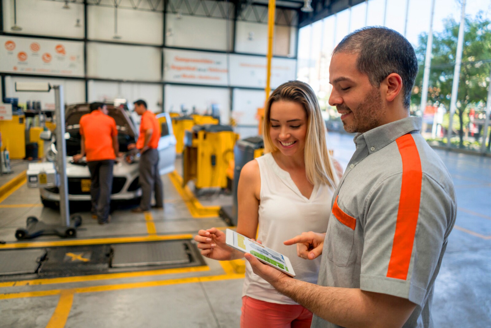 Subaru service advisor and customer reviewing a vehicle inspection in the service bay