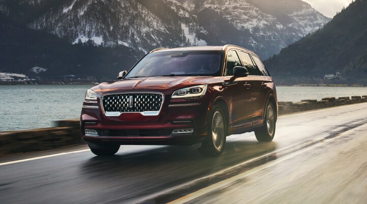 A 2021 Lincoln Aviator Grand touring is shown being driven in a river valley.