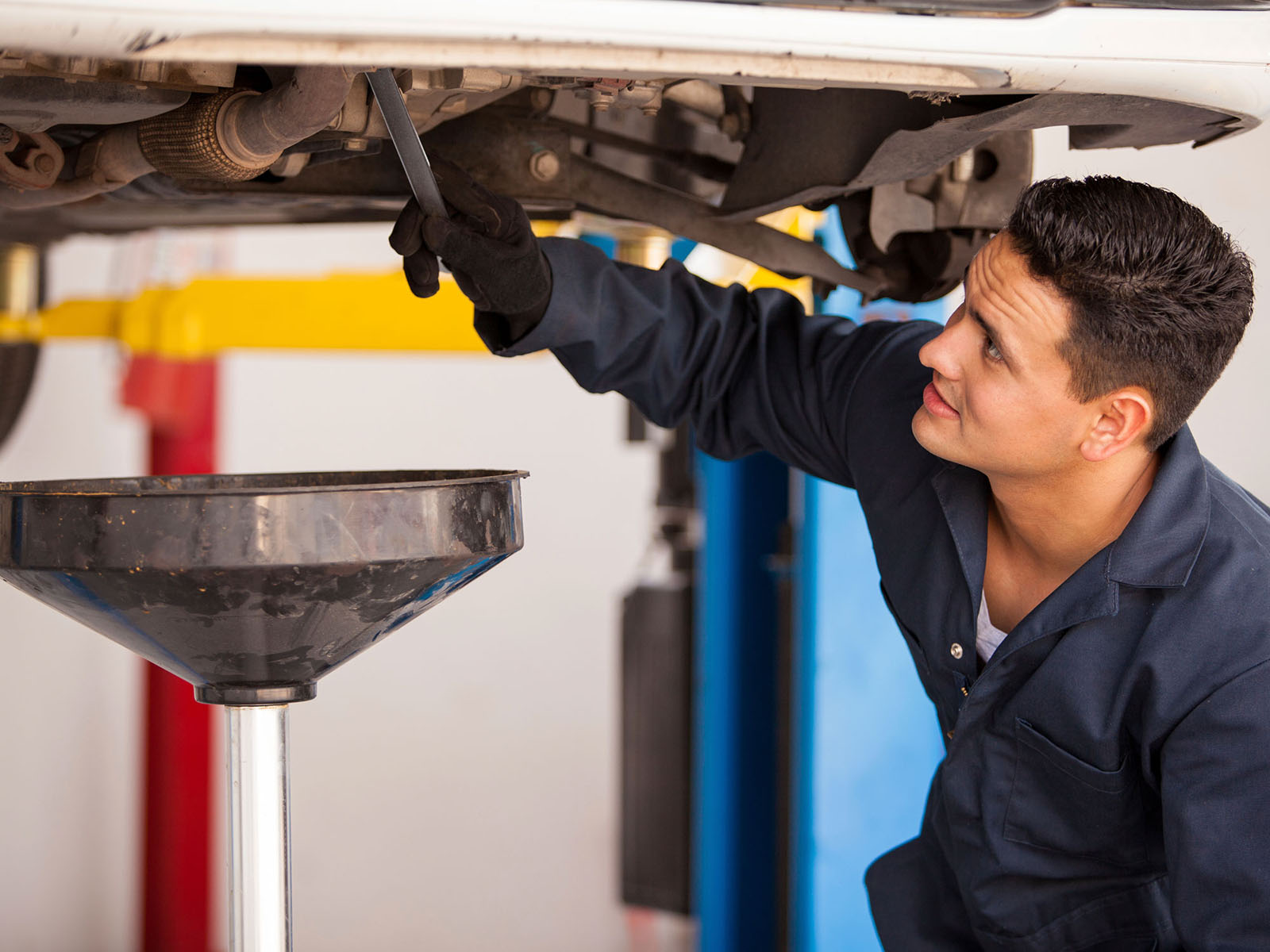 Técnico realizando un cambio de aceite y rotación de neumáticos en una camioneta Chevrolet SUV