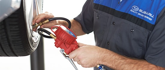Subaru Service Technician checking tire pressure