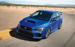 2020 WRX STI driving on track with desert and mountains in back