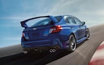 2020 WRX STI driving on track with blue sky and wispy clouds