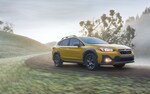 A 2021 Subaru Crosstrek Sport driving on a dirt road.