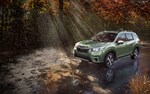 A 2021 Subaru Forester driving on a rainy country road.