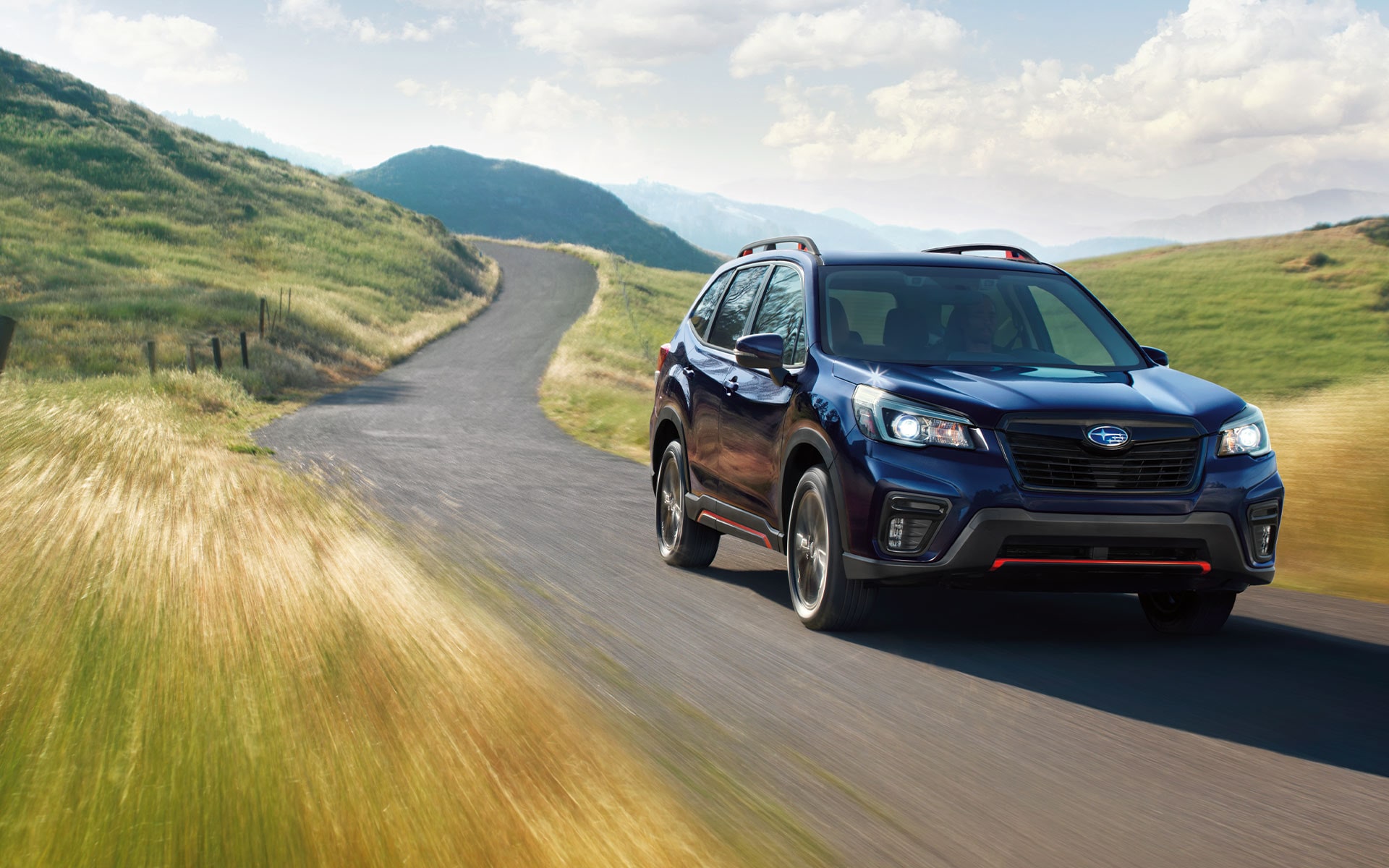 A 2021 Subaru Forester Sport driving on a country road.
