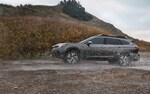 A 2021 Subaru Outback parked on a rocky beach.