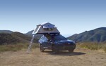A Subaru Outback with a tent on top of the vehicle
